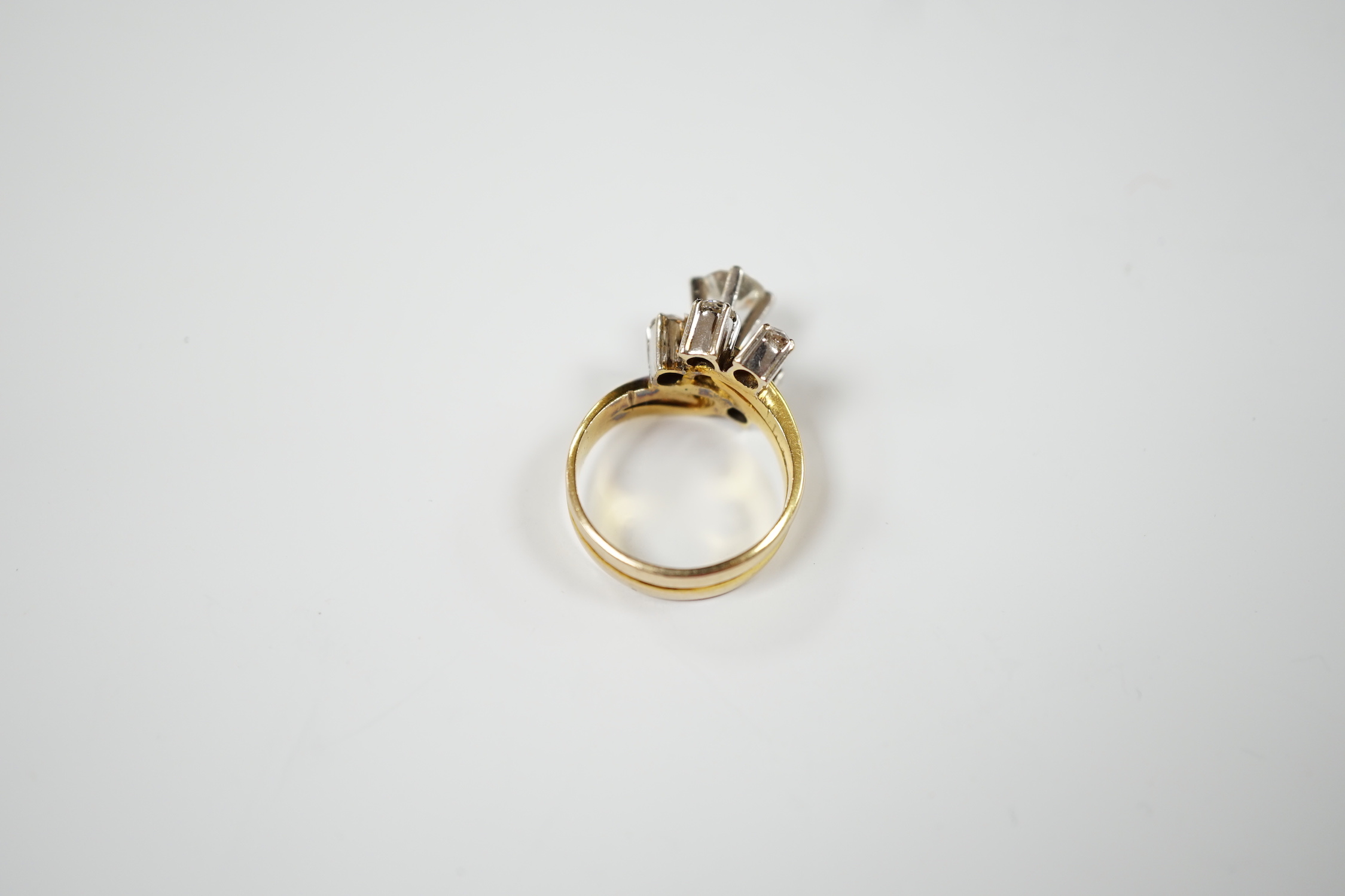 A yellow metal and graduated five stone diamond cluster set dress ring, in a raised setting, size J/K, gross weight 5.5 grams.